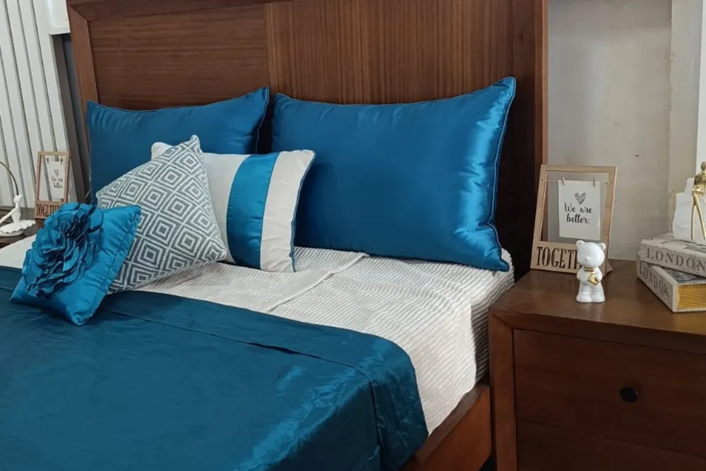 Dormitorio con cama y veladores de madera maciza en el showroom STYLHOUSE