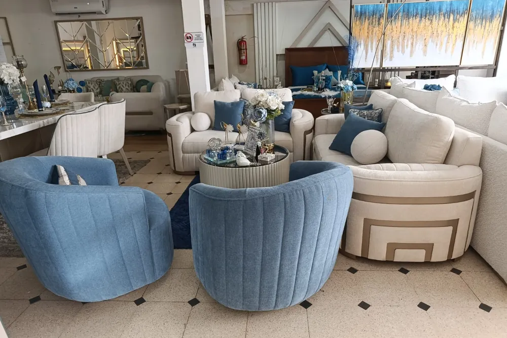 Ambiente contemporáneo con sillones azules y sofá curvo en el showroom STYLHOUSE