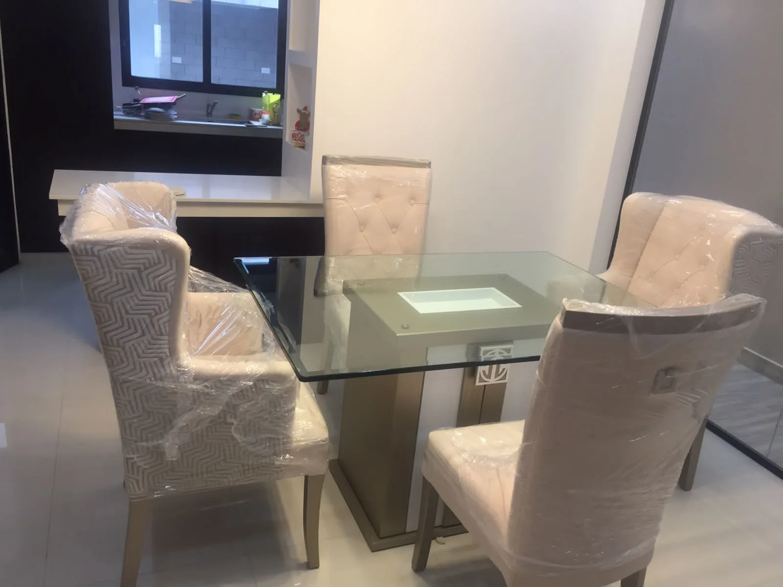 Comedor escena de mudanza/entrega con sillas y sofás envueltos en plástico