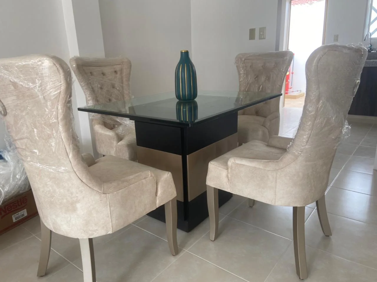 Comedor mesa vidrio con vajilla dorada puesta