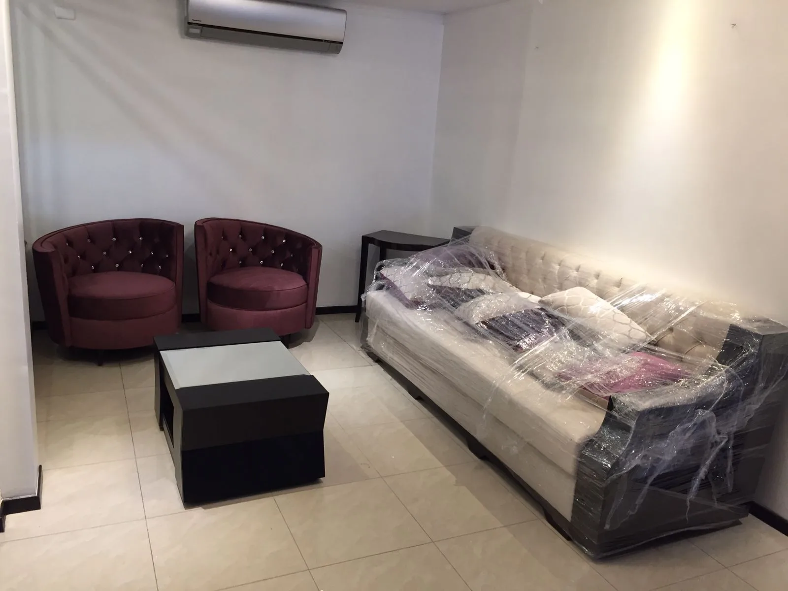 Sala a medida — sofá chesterfield crema con cojines naranja