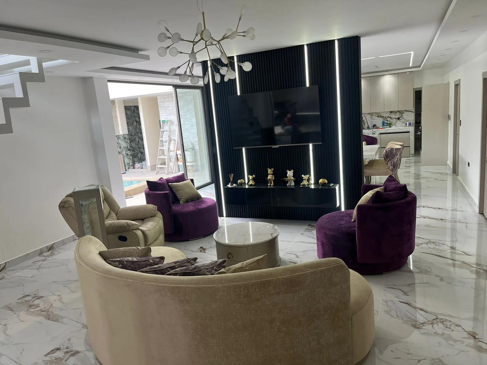Sala a medida — sofá curvo beige con sillones giratorios vino