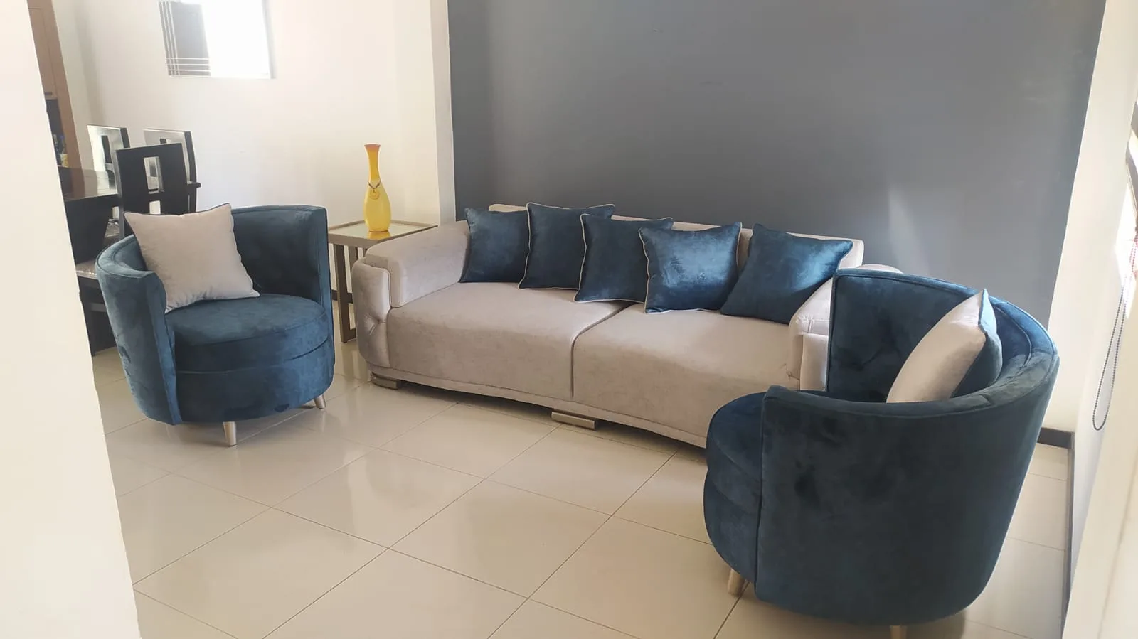 Sala a medida — sofá curvo crema con sillones giratorios teal