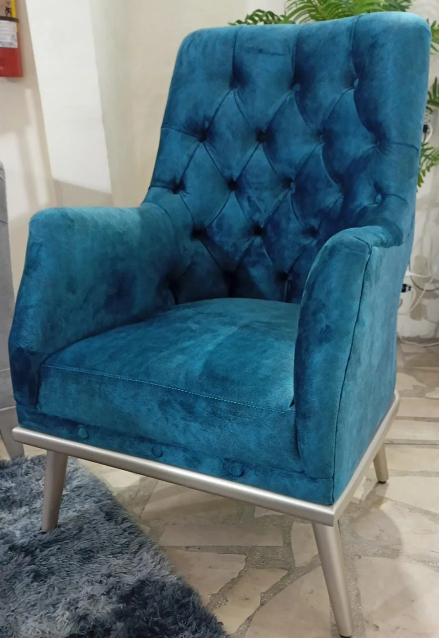 Sillón capitoné azul petróleo con patas cromadas